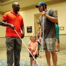 a father and daughter with cane getting a cane travel lesson.